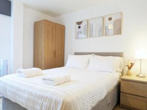 a bedroom with a large bed with two towels on it at Guest Rooms In City Centre Near Key Attractions in Liverpool