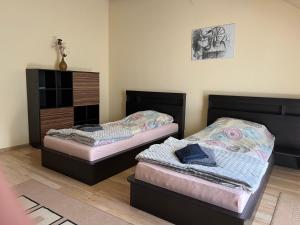 a room with two beds and a dresser at Apartament Orle Gniazdo in Reda