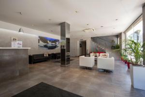 a lobby with white chairs and a reception desk at Hotel Del Pui in La Massana