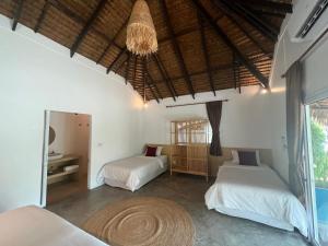 a bedroom with two beds and a chandelier at Sarana Bungalows in Baan Tai