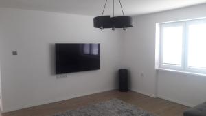 a living room with a flat screen tv on a white wall at House Juraj Čarný Zalužice 