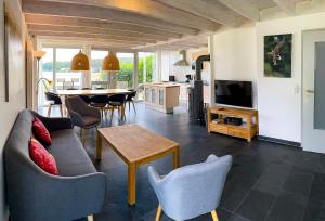 a living room with a couch and chairs and a table at Ferienhaus Wiesengeflüster S1 - mit Sauna, Kamin und Workation an der Müritz in Marienfelde