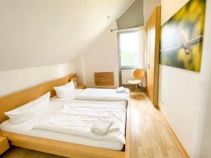 1 dormitorio con 2 camas y ventana en Ferienhaus Wiesengeflüster S1 - mit Sauna, Kamin und Workation an der Müritz en Marienfelde