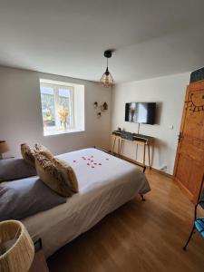 um quarto com uma cama, uma televisão e uma janela em Chambre d'hôte la Coquierrerie em Sottevast