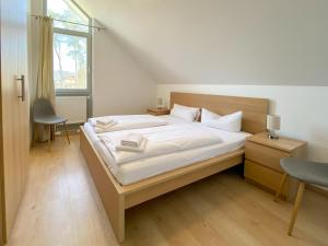 una camera da letto con un letto con lenzuola bianche e una finestra di Familienhaus Wiesengeflüster W11 - kinderfreundlich und nur 300 m zum Strand a Röbel