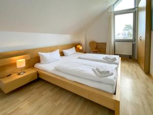 Schlafzimmer mit einem Bett mit weißer Bettwäsche und einem Fenster in der Unterkunft Gruppenhaus Wiesengeflüster S4 - in Randlage mit Sauna und Kamin in Röbel