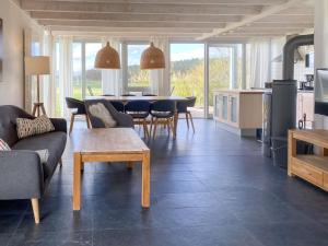 a living room with couches and a table and a kitchen at Gruppenunterkunft Wiesengeflüster S2 mit Wiesenblick, Sauna und Kamin in Röbel