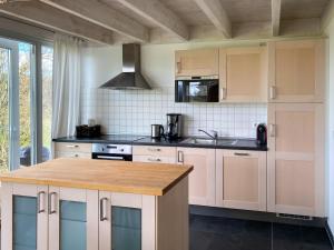 a kitchen with white cabinets and a wooden counter top at Gruppenunterkunft Wiesengeflüster S2 mit Wiesenblick, Sauna und Kamin in Röbel