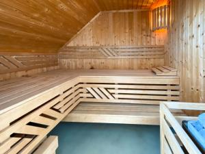 a wooden sauna with blue seats in it at Gruppenunterkunft Wiesengeflüster S2 mit Wiesenblick, Sauna und Kamin in Röbel +33 photos