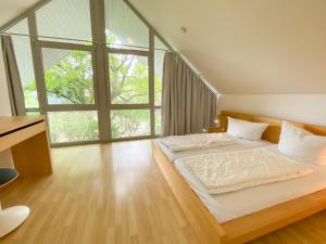 a bedroom with a large bed with a large window at Ferienhaus Wiesengeflüster E3 - familienfreundlich nur 3 Minuten zum Strand in Röbel