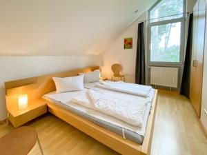 a large bed in a room with a large window at Ferienhaus Wiesengeflüster E3 - familienfreundlich nur 3 Minuten zum Strand in Röbel