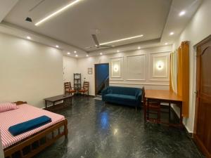 a room with two beds and a table and a couch at Palolem Apartments in Palolem