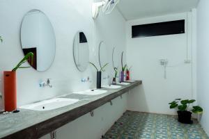 a bathroom with a row of sinks and mirrors at ANOU HOSTEL in Pakse