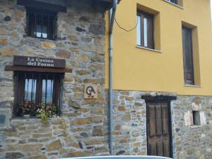 een geel gebouw met een bord aan de zijkant bij La Casina Del Fornu in Pravia +3 foto's