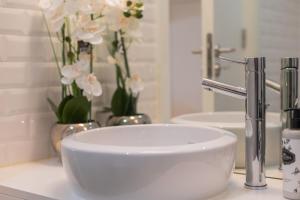 a white sink on a counter with flowers in a bathroom at Nautical Luxury Loft in Porto +19 photos