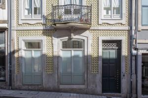 a building with two doors and a balcony on it at Nautical Luxury Loft in Porto