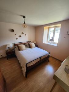 Un dormitorio con una cama grande y una ventana en Chambre d'hôte la Coquierrerie, en Sottevast