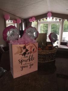 uma mesa com um cesto com um cartaz e balões em Scarletts Escape - Percy Wood em Morpeth