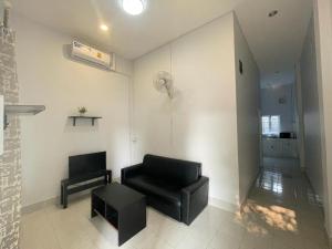 uma sala de espera com uma cadeira preta e uma mesa em VS appartment em Vientiane