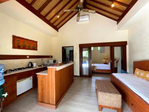 a kitchen with a table and a couch in a room at 1 BR Balinese Villa In The Heart of Sanur in Sanur