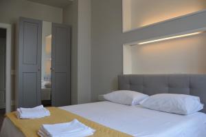 a bedroom with a bed with white sheets and pillows at Via Roma in Reggio di Calabria