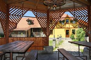 a wooden pavilion with two wooden tables and a building at Pensiunea Bendorfeanu in Răşinari