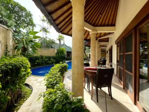 a patio with a table and chairs next to a pool at 1 BR Balinese Villa In The Heart of Sanur in Sanur
