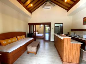 a living room with a couch and a kitchen at 1 BR Balinese Villa In The Heart of Sanur in Sanur