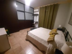 Schlafzimmer mit einem Bett und einem Fenster in der Unterkunft San Nicolò House in Aci Catena