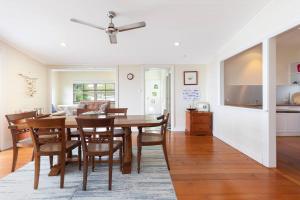 een keuken en eetkamer met een tafel en stoelen bij Coastal Queenslander with Fraser Island Views in Boonooroo