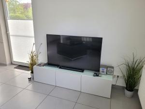 a large flat screen tv sitting on a white cabinet at Ferienhaus Gammendorf in Gammendorf