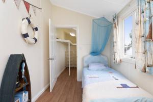 um pequeno quarto com uma cama e uma janela em Coastal Queenslander with Fraser Island Views em Boonooroo