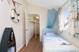 een kleine kamer met een bed en een raam bij Coastal Queenslander with Fraser Island Views in Boonooroo