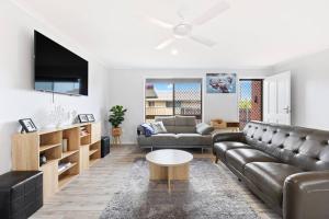 uma sala de estar com um sofá e uma mesa em 'The Aussie Classic' Poolside Living by the Marina em Urangan