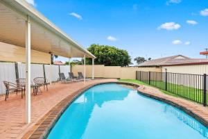 a swimming pool in the backyard of a house at 'The Aussie Classic' Poolside Living by the Marina in Urangan
