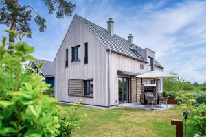 uma casa estilo celeiro com um telhado de gambrel em SandDorn 1 und 2 em Pruchten