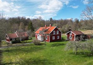 a group of houses in a field with grass at Villa Vilan - Countryside Lodging in Skillingaryd