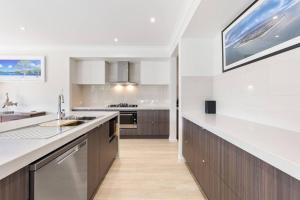a kitchen with a sink and a counter top at Luxe By The Marina - Hamptons Chic at Hervey Bay in Urangan