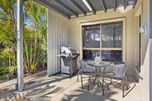 eine Terrasse mit einem Tisch, Stühlen und einem Grill in der Unterkunft Torquay Beach Splendour - An Expansive Family Stay in Torquay