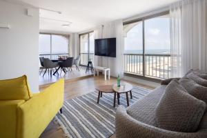 een woonkamer met een bank, een tv en een tafel bij Grand Sea View Retreat by Sea N' Rent in Tel Aviv