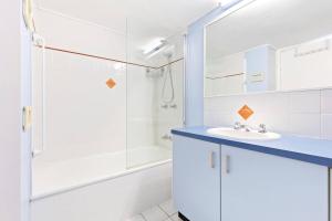 a white bathroom with a sink and a shower at Sandy Straits Poolside Escape with Beach Access in Hervey Bay