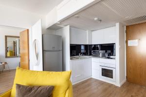 een keuken met witte kasten en een gele stoel bij Grand Sea View Retreat by Sea N' Rent in Tel Aviv