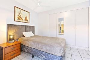 a bedroom with a bed and a wooden dresser at Sandy Straits Poolside Escape with Beach Access in Hervey Bay