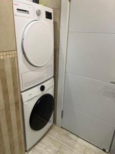 a washing machine and a microwave in a kitchen at Center boutique Apartment in Netanya