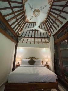 Schlafzimmer mit einem Bett mit Holzdecke in der Unterkunft Bali Maison in Ubud