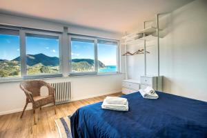 1 dormitorio con 1 cama azul y ventanas grandes en 100b - VILLA Ginestra, ampia Terrazza 120m2 vista mare 10 minuti a piedi spiaggia, 3 camere da letto, en Sestri Levante