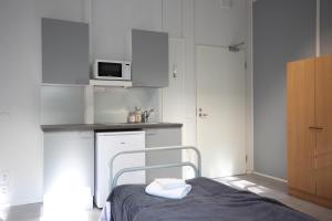 a small kitchen with a bed and a microwave at Forenom Hostel Espoo Kilo in Espoo