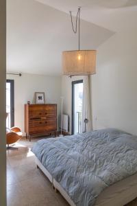 Un dormitorio con una cama y una cómoda y una ventana. en La Provenca villa 29, en Malaucène