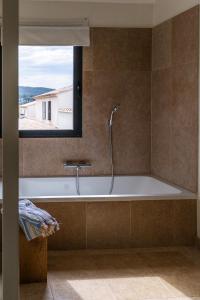 una bañera en un baño con ventana en La Provenca villa 29, en Malaucène