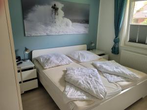a bed with white sheets and pillows in a bedroom at Ferienhaus Gammendorf in Gammendorf